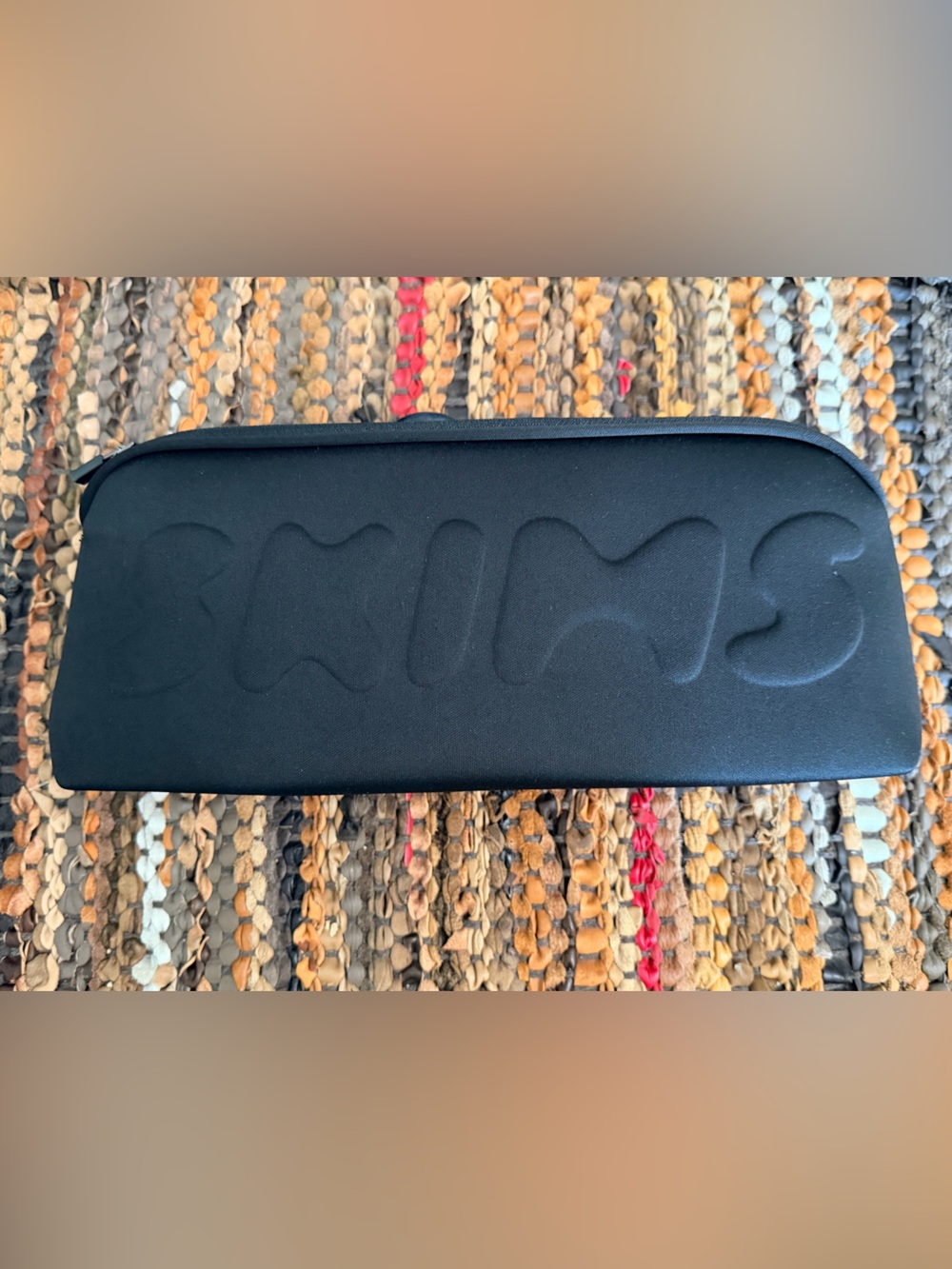 SKIMS neoprene pouch in black onyx features a raised logo. New with Tags.